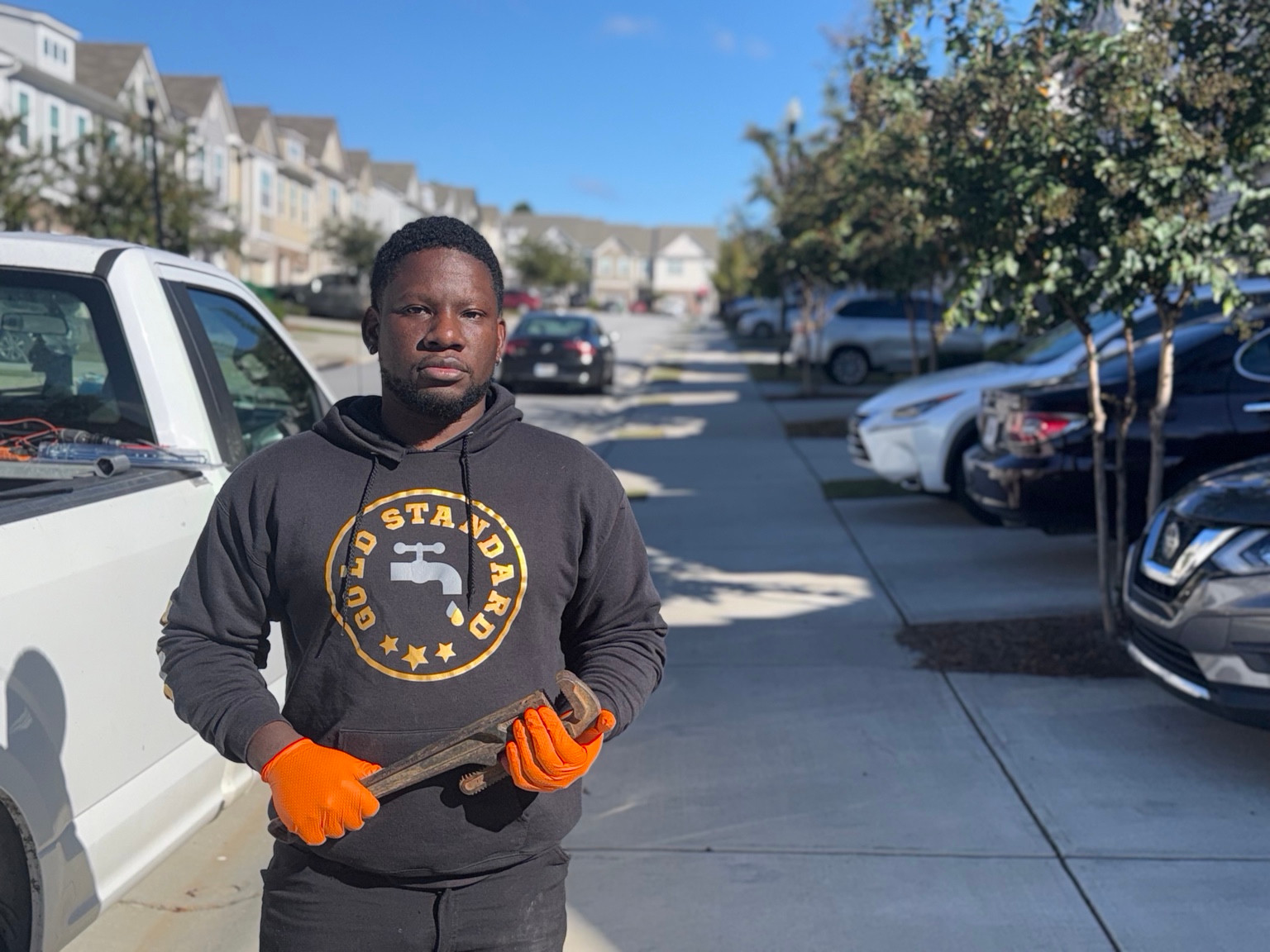 Zee of Gold Standard Plumbing holding a pipe wrench