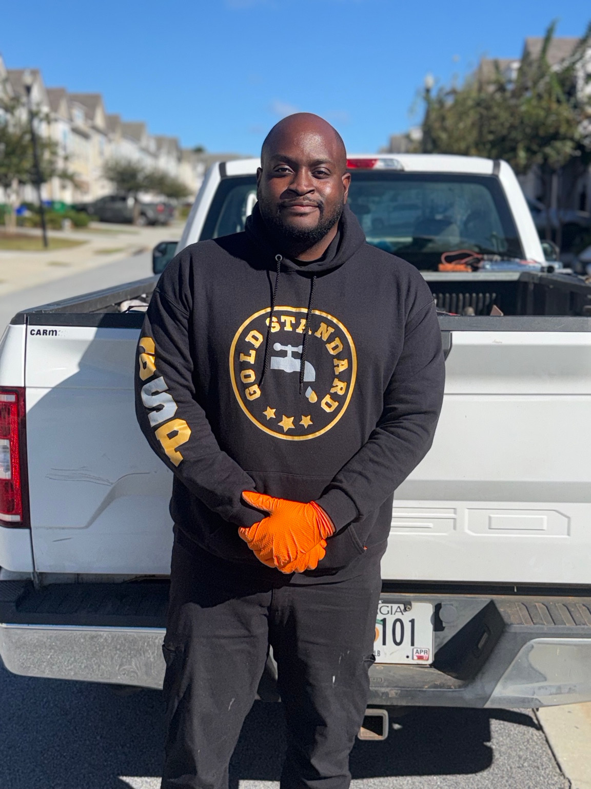 Kenny of Gold Standard Plumbing beside the work truck